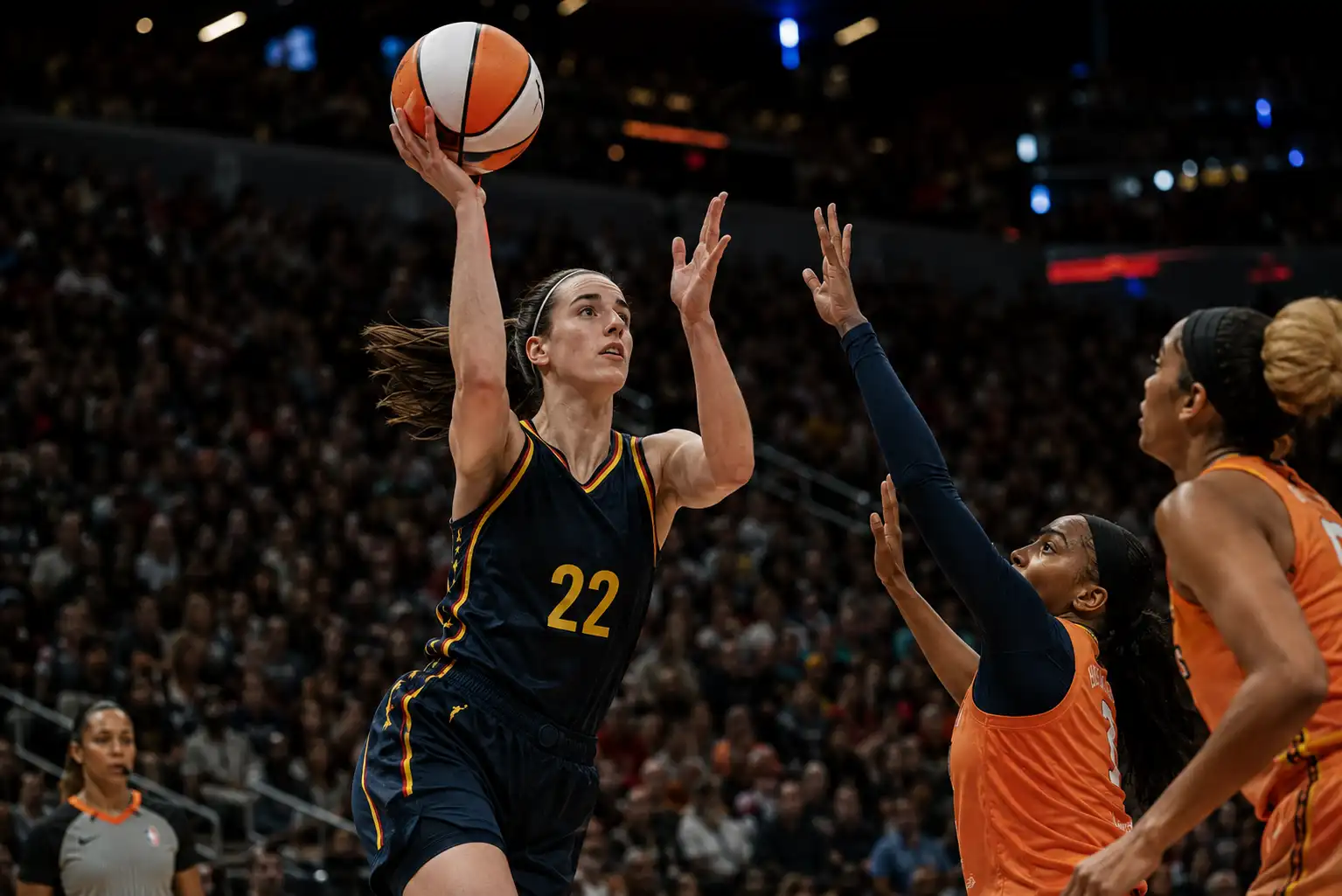 Caitlin Clark playing during a women’s basketball game in a packed arena